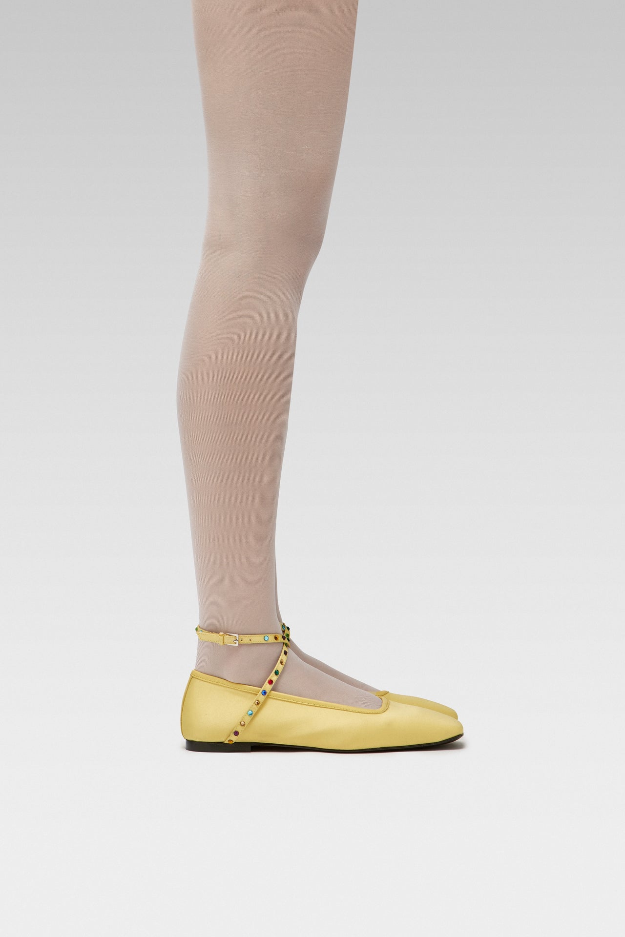 EDLA Galaxy White tights Crafted from a silky 20 denier finish, the Galaxy Tights feature a sheer body, shaped silhouette, and invisible toe together with EDLA Butter Yellow Saturn ballet flats Crafted from butter yellow satin, the Saturn Ballet Flat features multicolored crystal-embellished straps and a squared toe.