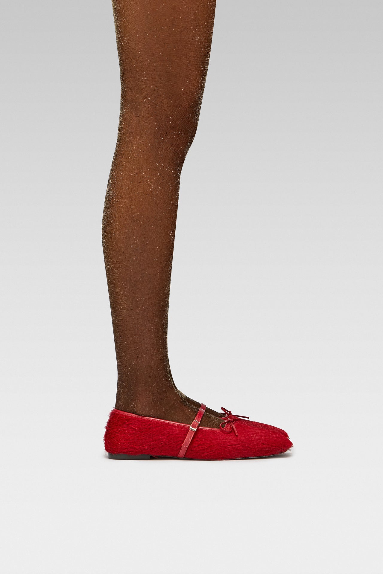 EDLA Cosmic Lurex Tights Crafted from a 40 denier finish with metallised fibre, the Cosmic Gold Lurex Tights feature a subtle shimmer with EDLA Mars Ballet red Flat Crafted from hair calf, the Mars Ballet Flat features a front strap, bow detail, and a squared toe.