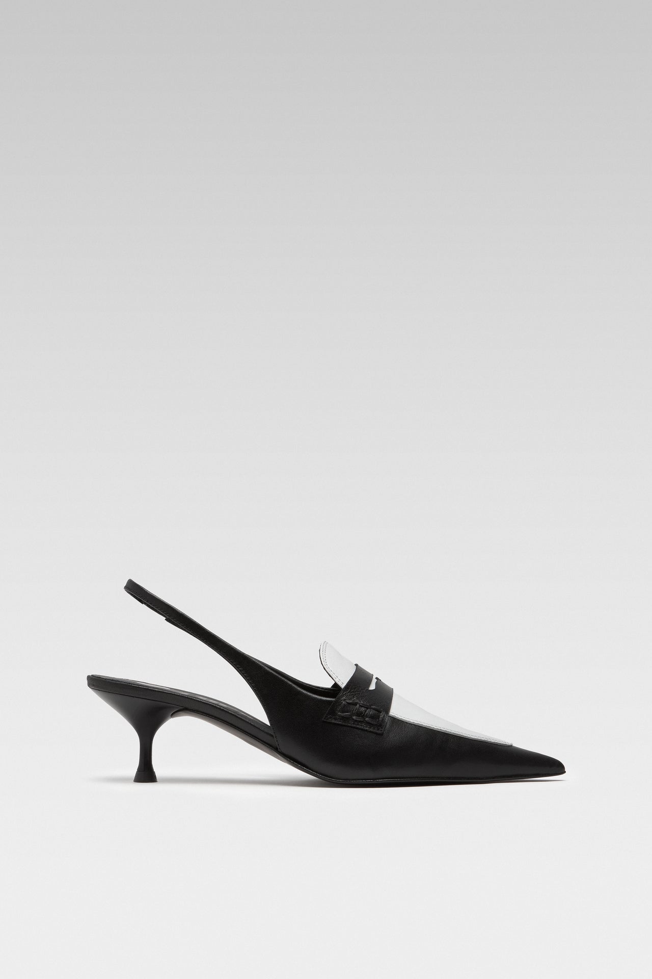 Side view of EDLA Uranus black-and-white slingback kitten heels made from leather and designed with a pointed toe and penny loafer-style front.