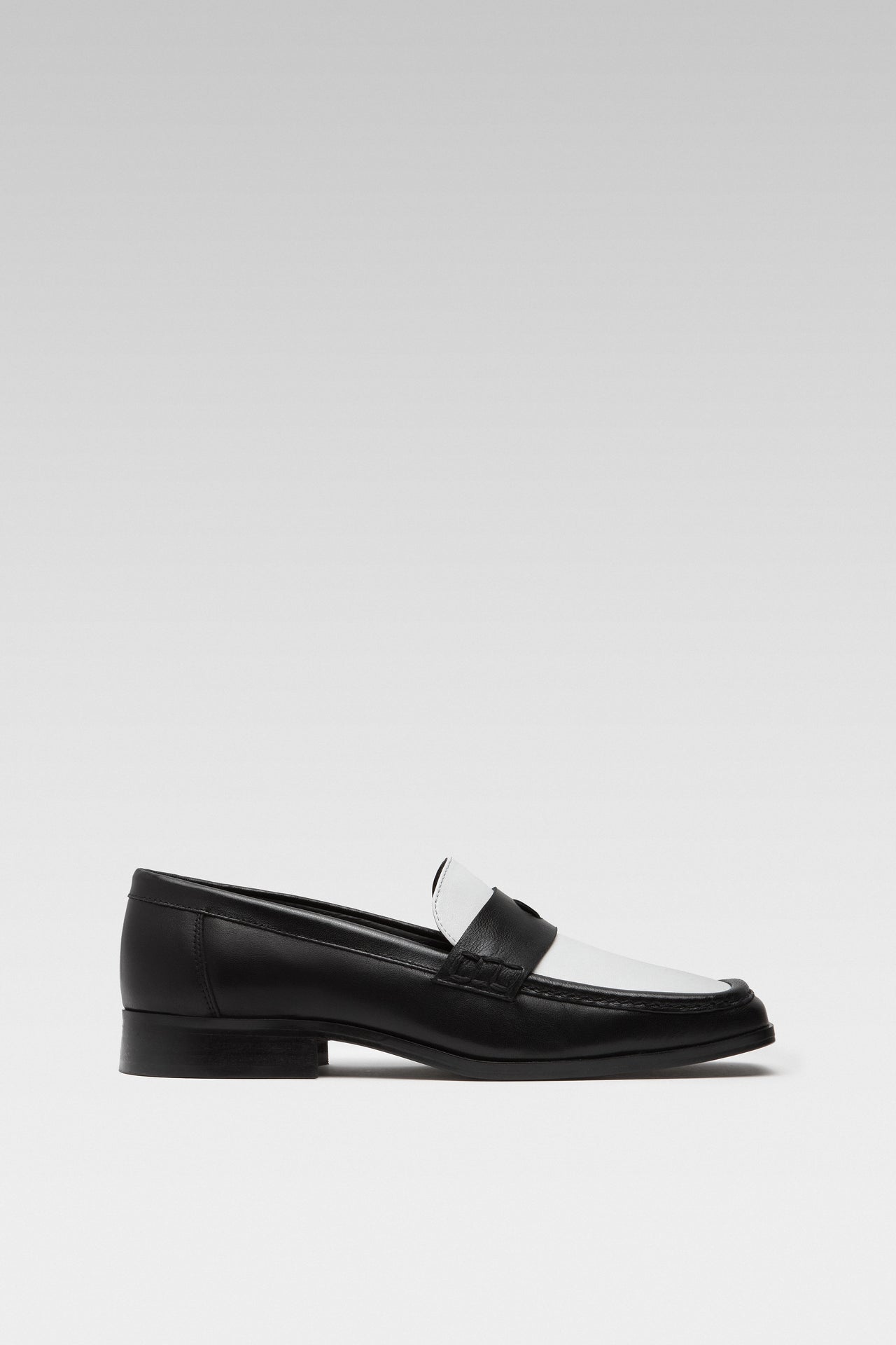 Side view of EDLA Earth black-and-white penny loafers for women crafted from leather with a square toe.