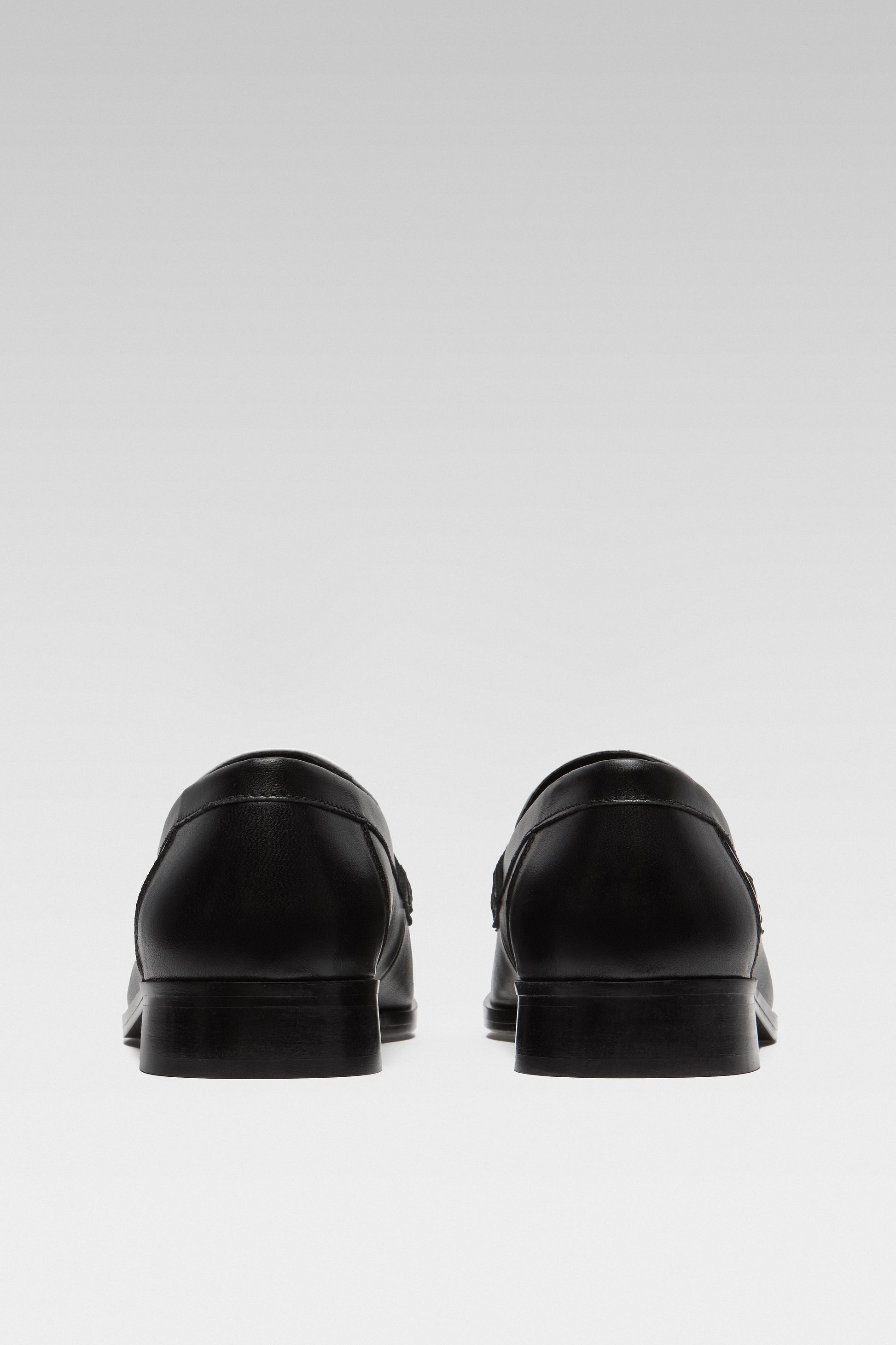 Back view of EDLA Earth black-and-white loafers for women crafted from leather.
