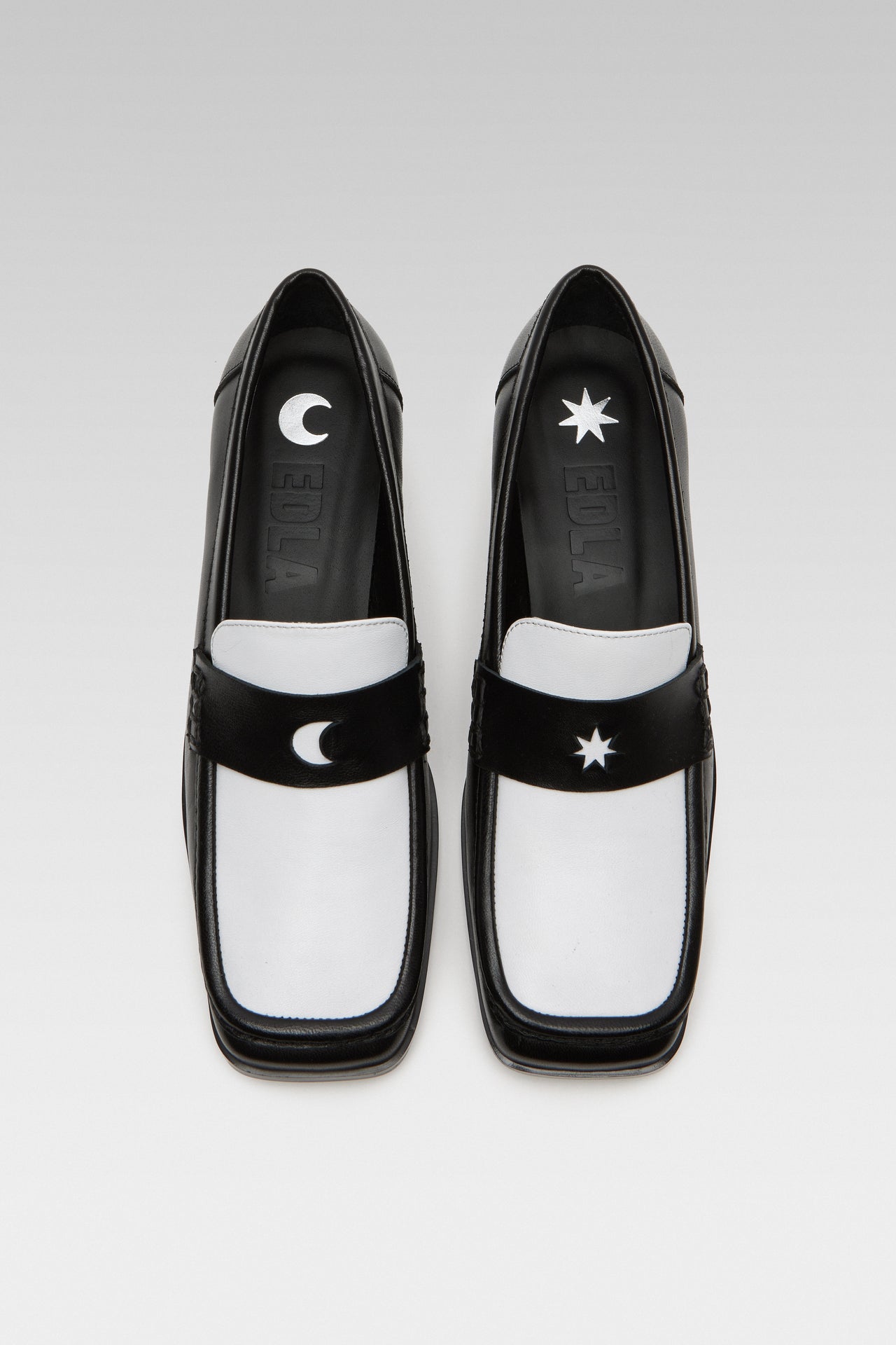 Side view of EDLA Earth black-and-white penny loafers for women crafted from leather with a square toe.