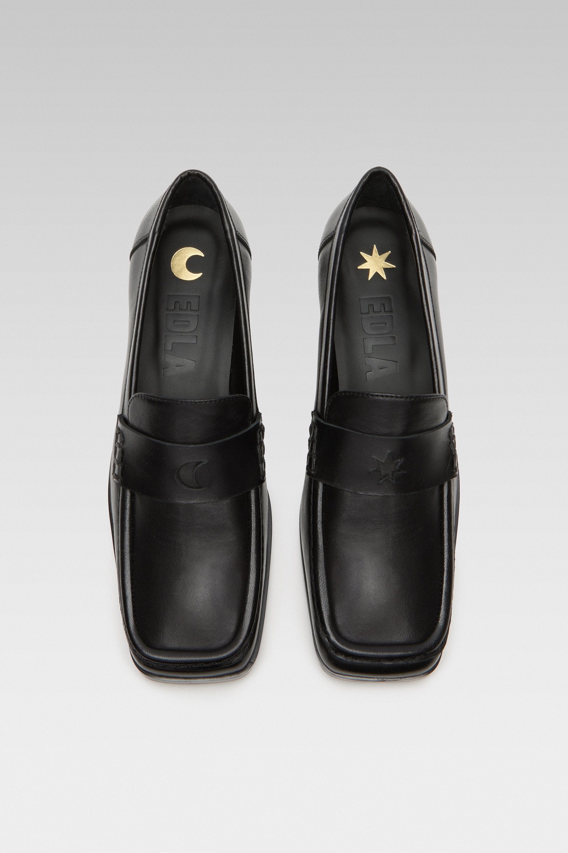 Top view of EDLA Earth black loafers for women crafted from leather with a square toe and star and moon inserts at the front.