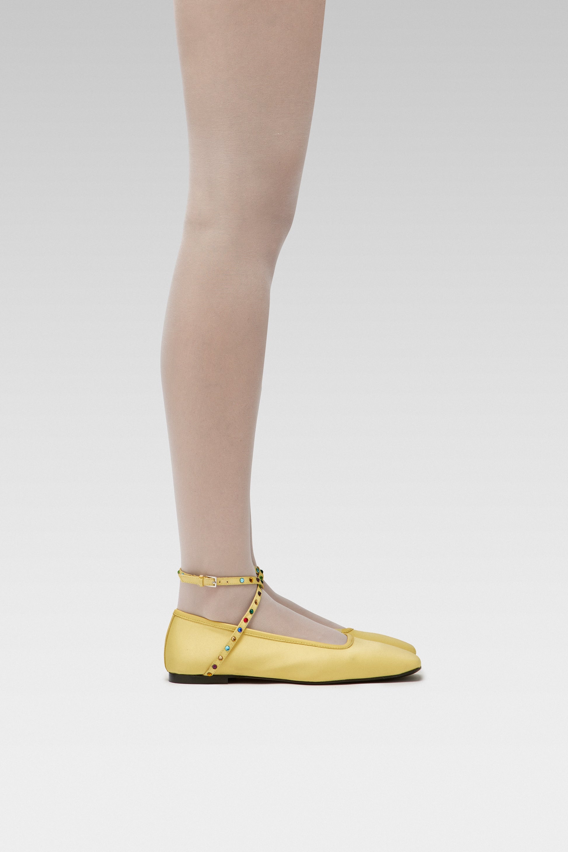 EDLA Galaxy White tights Crafted from a silky 20 denier finish, the Galaxy Tights feature a sheer body, shaped silhouette, and invisible toe together with EDLA Butter Yellow Saturn ballet flats Crafted from butter yellow satin, the Saturn Ballet Flat features multicolored crystal-embellished straps and a squared toe.