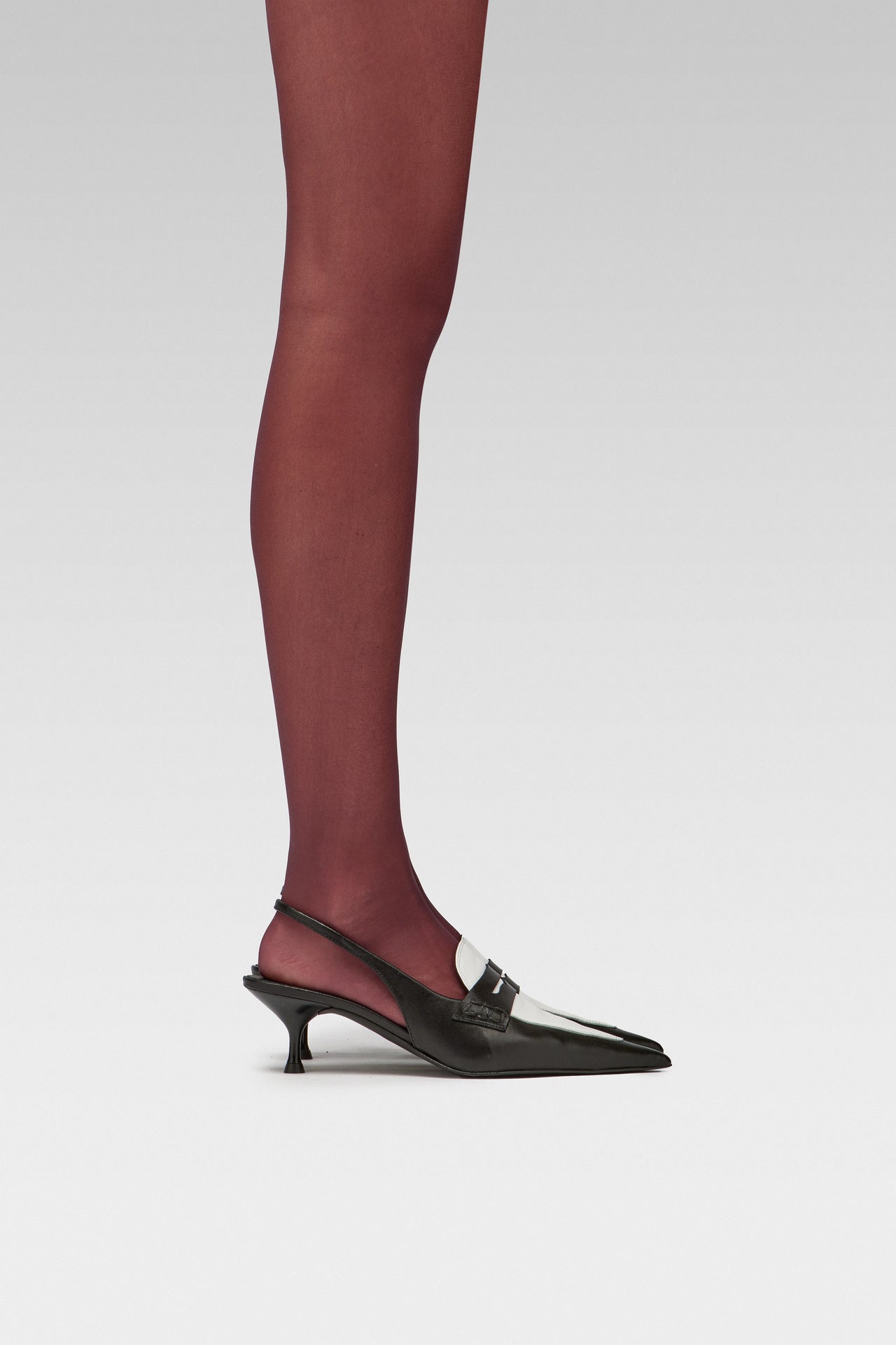 EDLA Galaxy Burgundy tights with EDLA Uranus Slingback black and white kitten heel Crafted in soft nappa lambskin, the Uranus Slingback features a pointed toe, penny loafer-inspired band, and a 5cm kitten heel. 