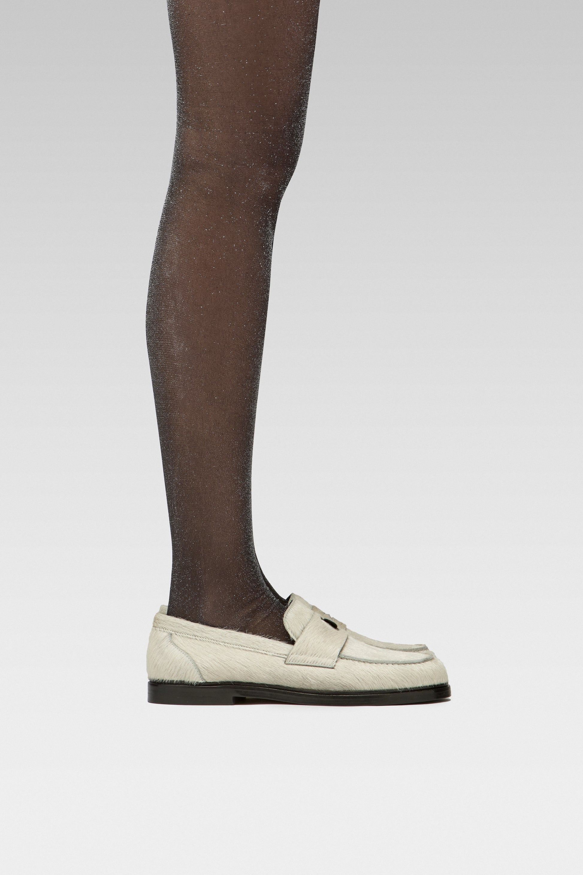 EDLA Cosmic Lurex Crafted from a 40 denier finish with metallised fibre, the Cosmic Silver Lurex Tights feature a subtle shimmer together with EDLA Jupiter white hair calf Loafer. 