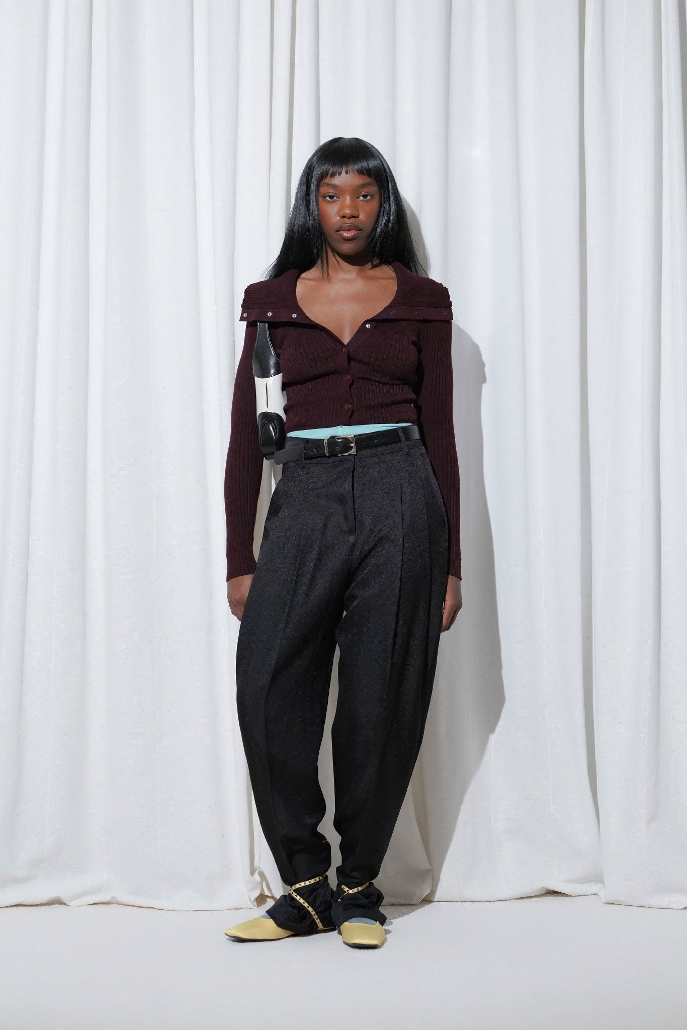 Model in a casual work outfit with burgundy off-shoulder cardigan, black trousers, EDLA Galaxy Aquamarine Tights and EDLA Saturn Yellow Ballet Flats.