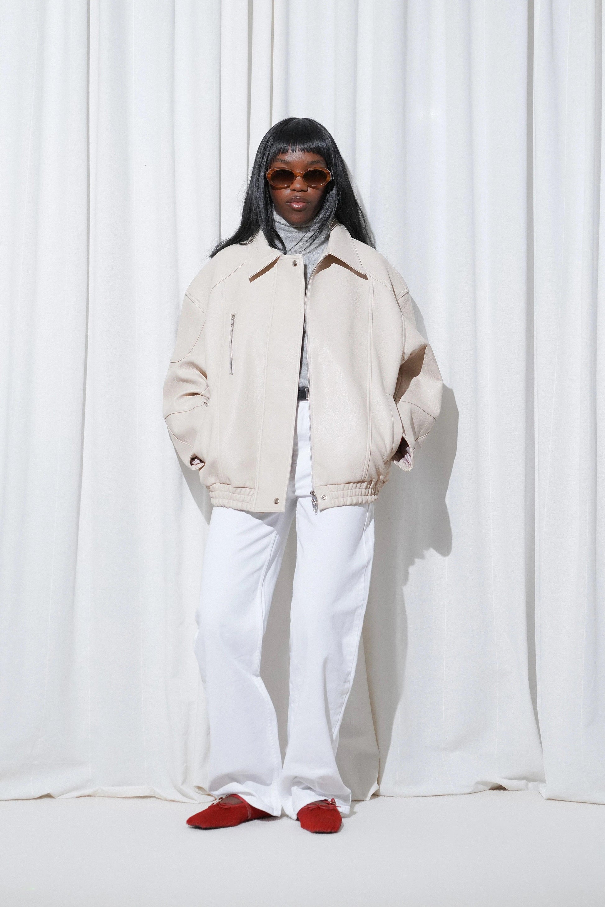 Model in a casual outfit with beige oversized jacket, grey turtleneck, white wide-leg pants, and EDLA Mars Red Ballet Flats.