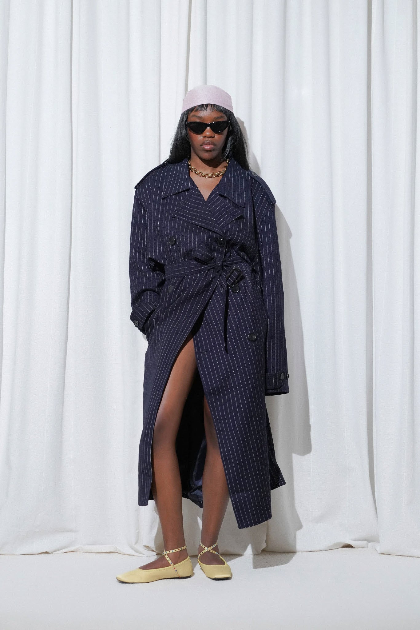 Model in a casual outfit with navy pinstripe trench coat, pink headscarf, gold necklace, and EDLA Saturn Yellow Ballet Flats.