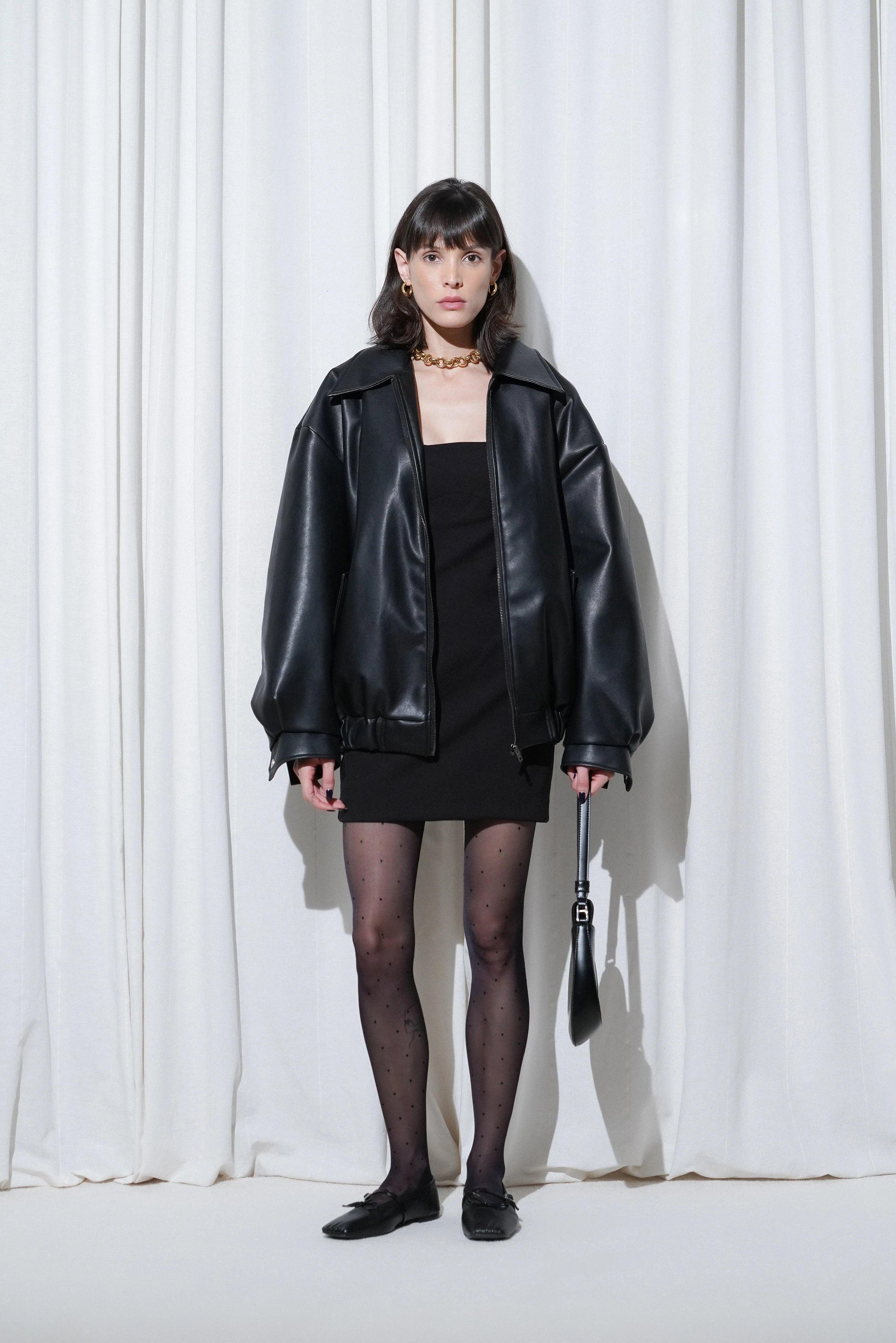 Model wearing a party outfit with EDLA Orbit Black Polka Dots Tights, Mars Black Ballet Flats, mini dress and leather jacket.