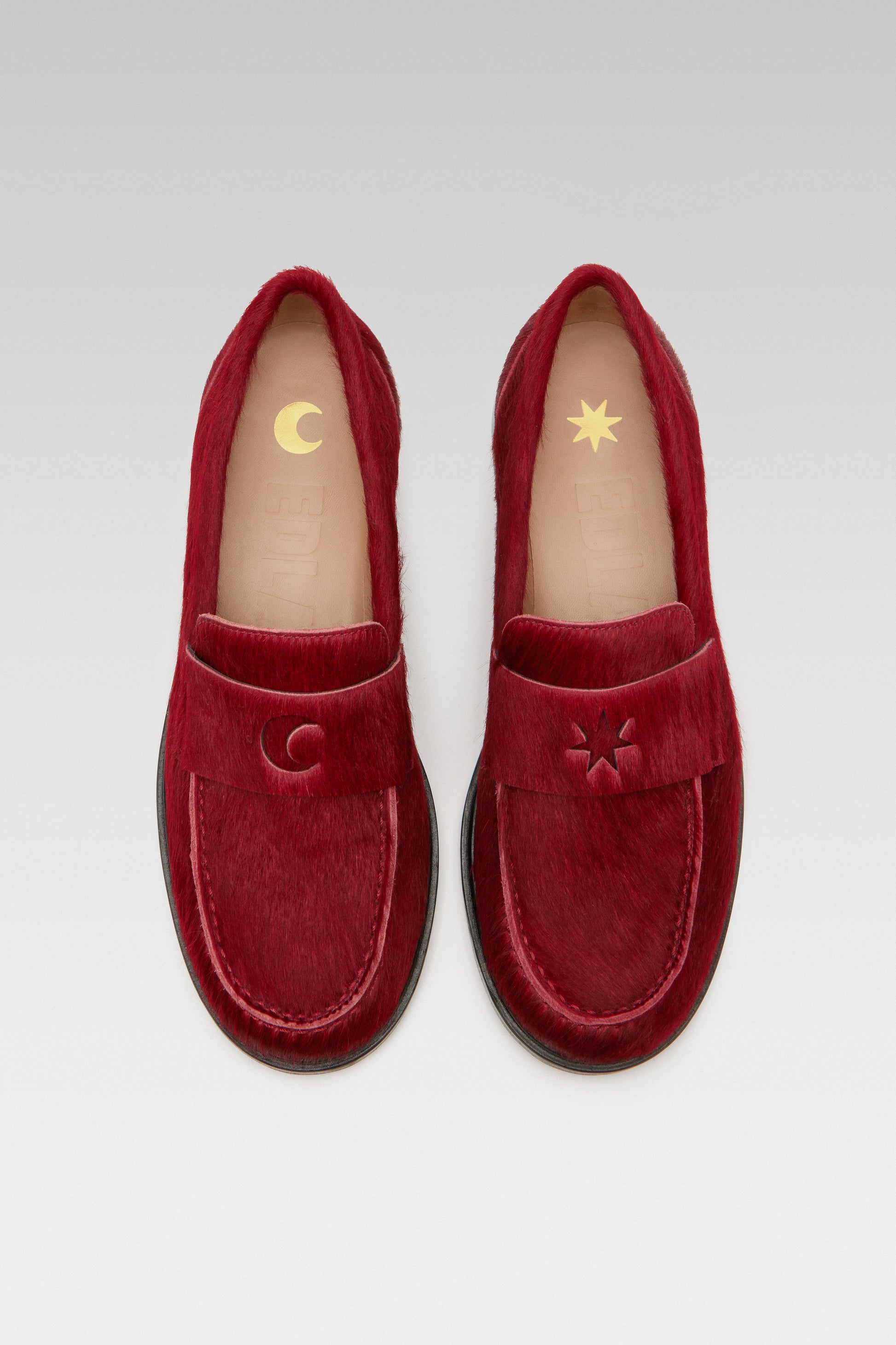 Top view of EDLA Jupiter red loafers for women crafted from calf hair with a round toe and star and moon inserts at the front.