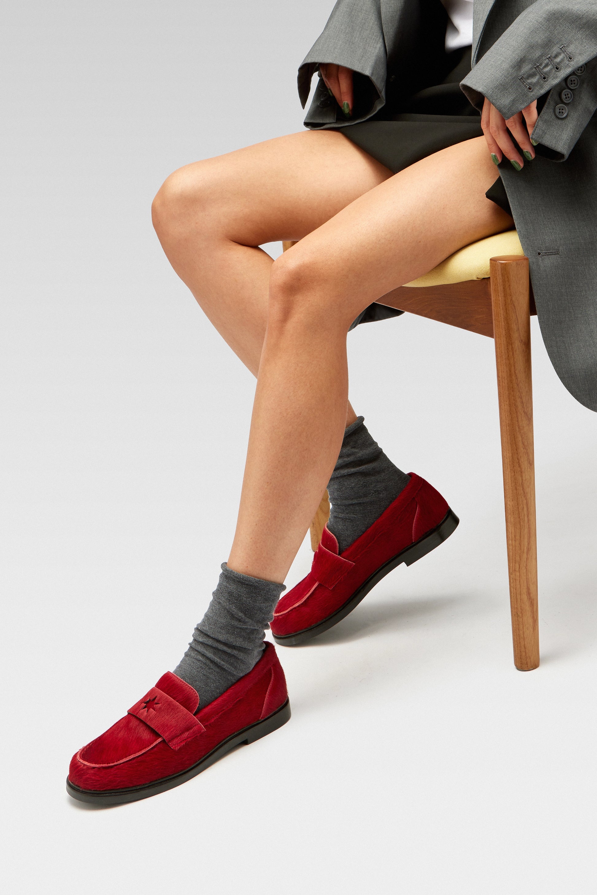 A model wearing EDLA Jupiter red loafers for women, styled with EDLA Ursa grey socks.