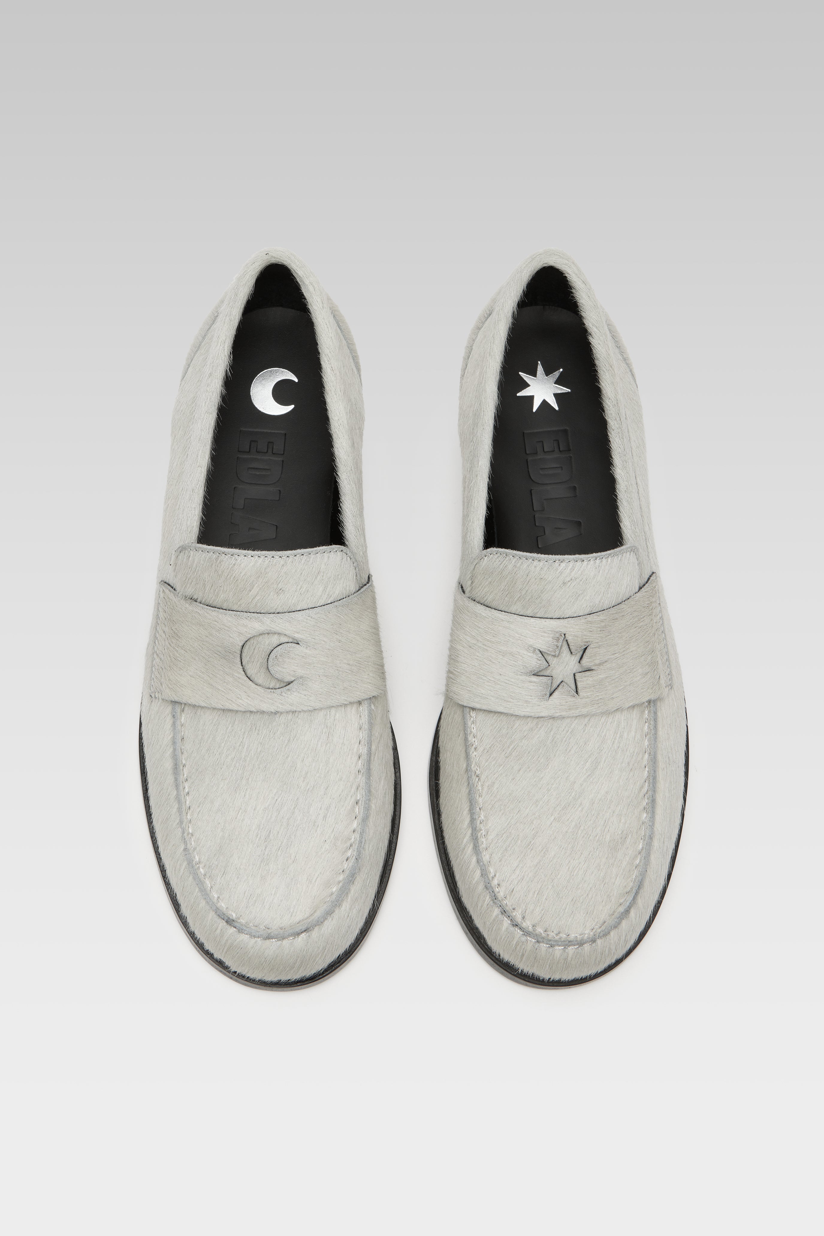 Top view of EDLA Jupiter white loafers for women crafted from calf hair with a round toe and star and moon inserts at the front.