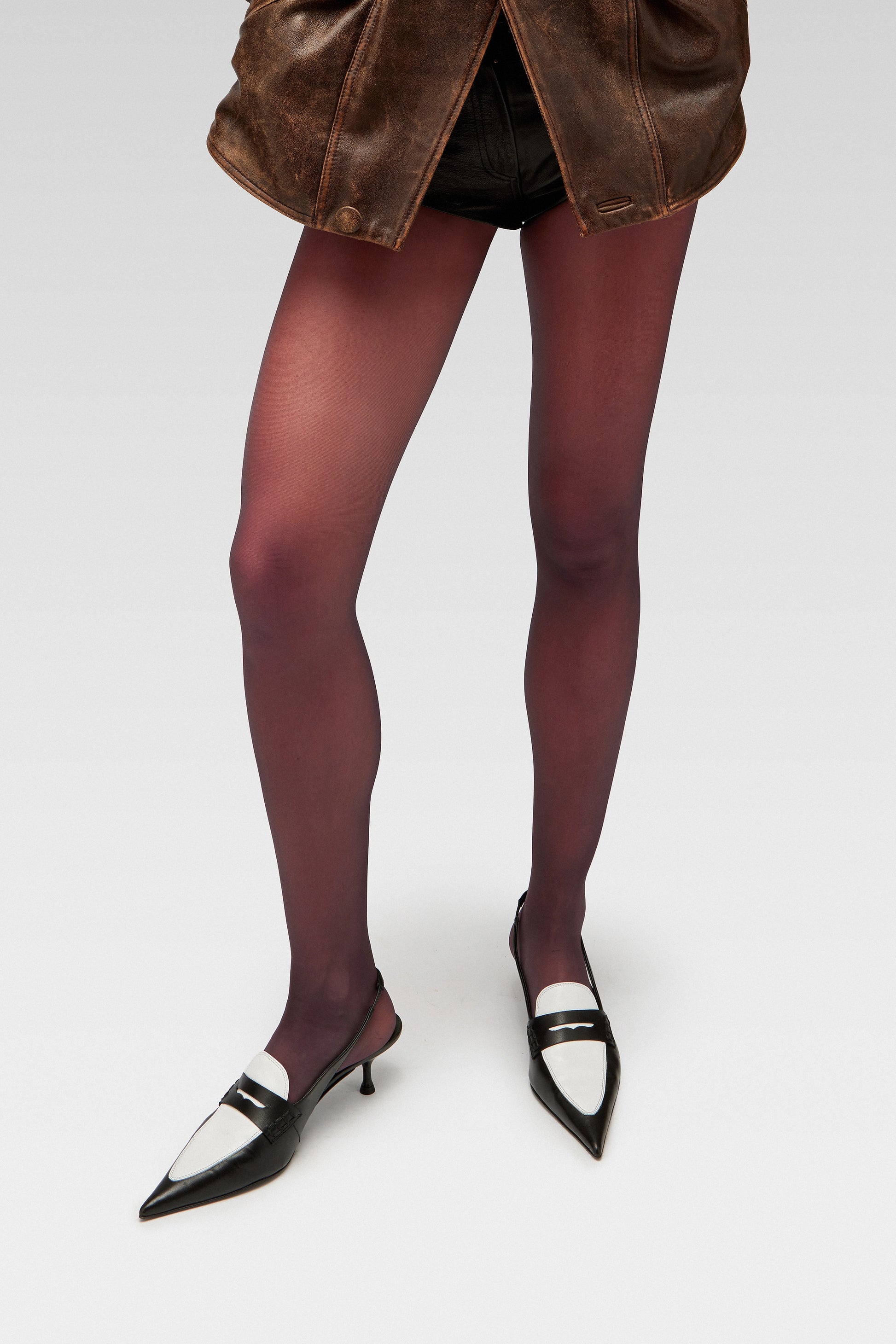 Model wearing EDLA Uranus black-and-white kitten heels with EDLA Galaxy burgundy tights. A business casual women’s shoe crafted for a sleek and modern look.