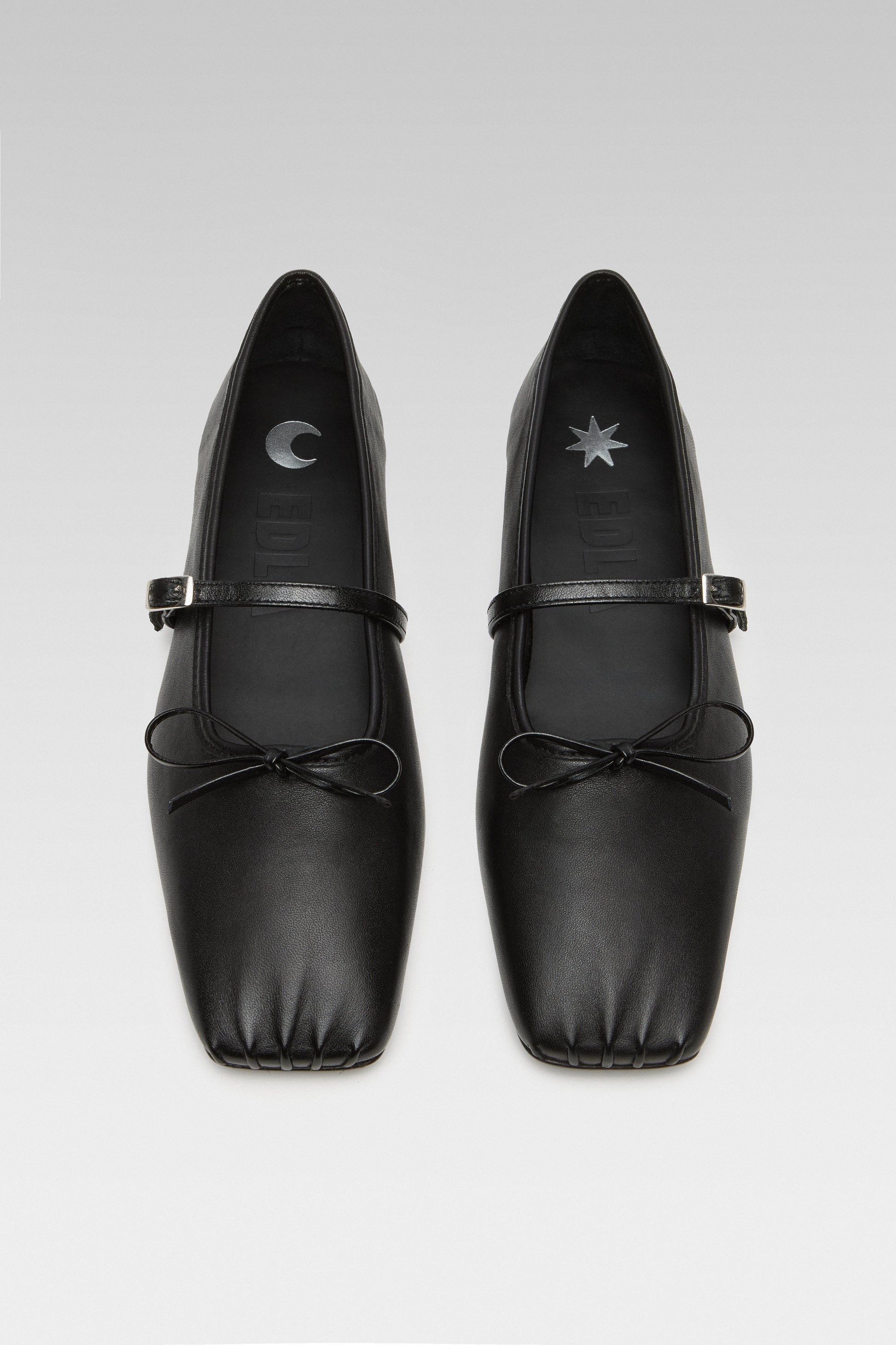 Top view of EDLA Mars black ballet flats crafted from leather with a squared toe and bow detail.