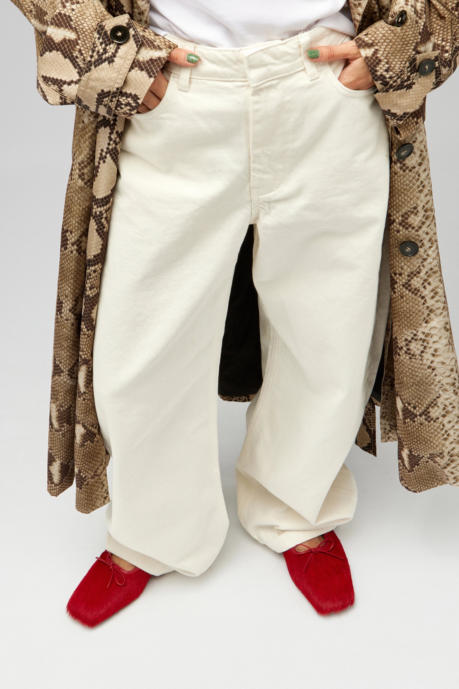 Model wearing white jeans with EDLA Mars red ballet flats crafted from calf hair.