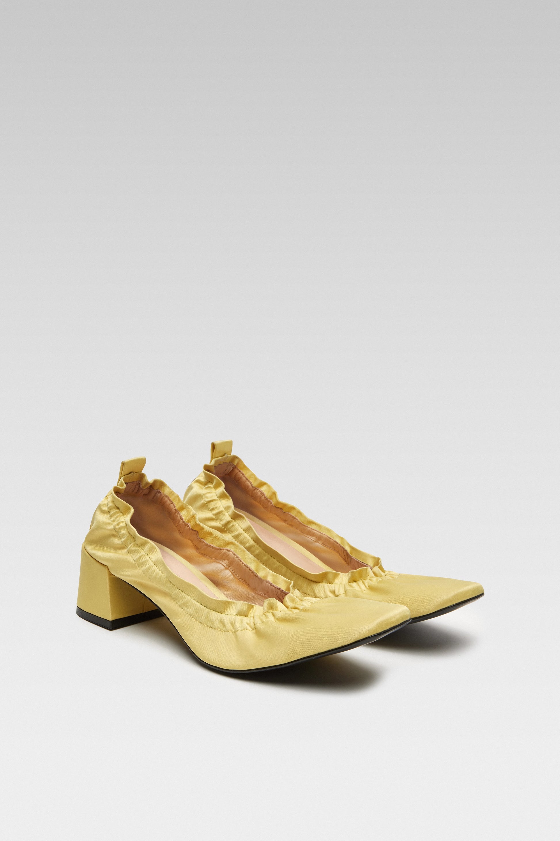 Three-quarter view of EDLA Mercury yellow kitten heels crafted from satin with a block heel, squared toe and elastic ruched band.