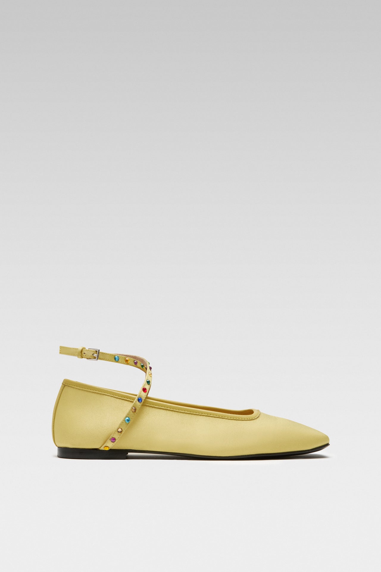 Side view of EDLA Saturn yellow ballet flats crafted from satin with ankle straps embellished with multicoloured crystals.