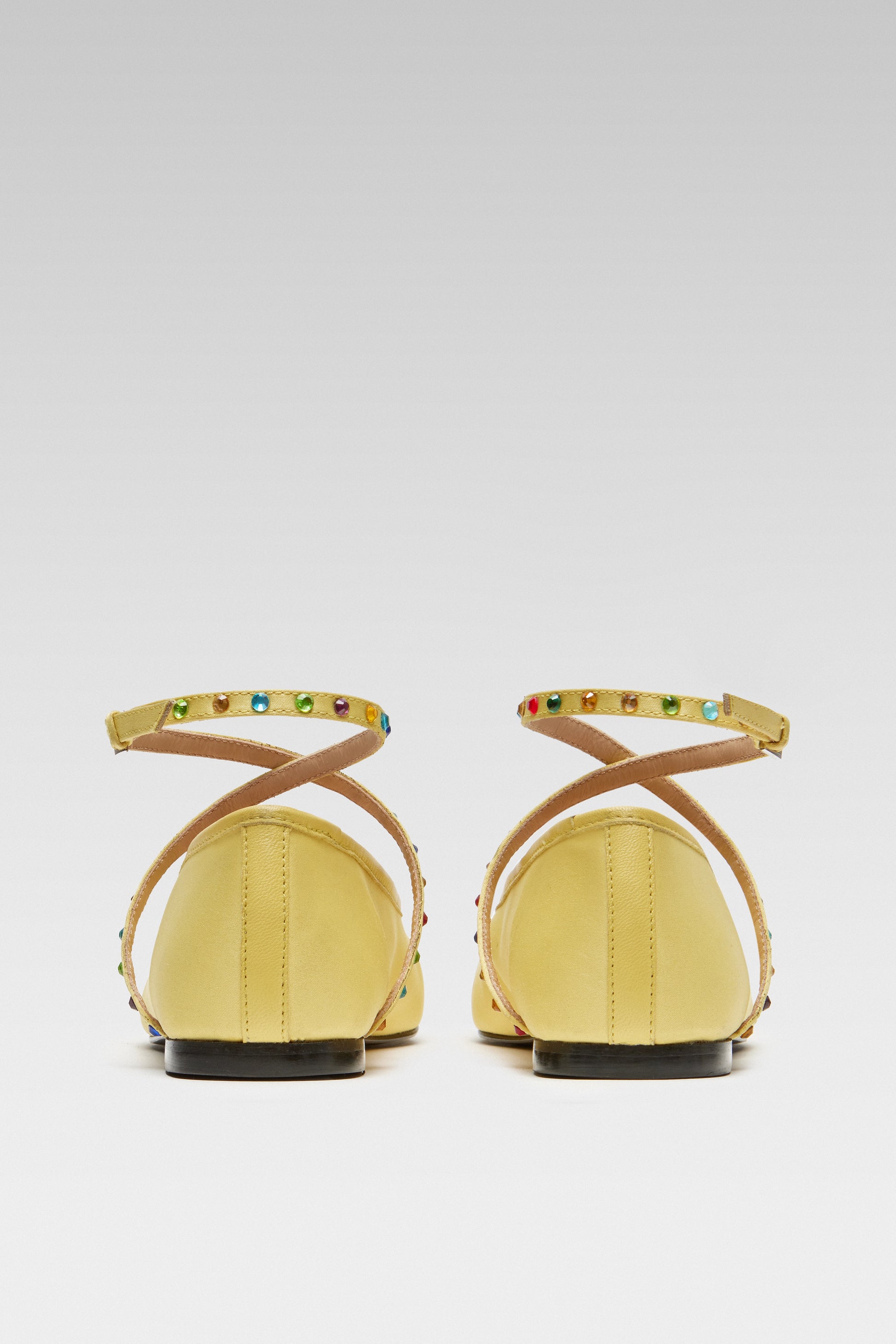 Back view of EDLA Saturn yellow ballet flats crafted from satin with ankle straps embellished with multicoloured crystals.